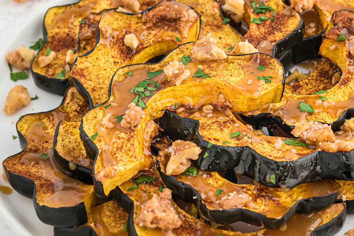 close up of acorn squash slices with maple sauce and candied walnuts