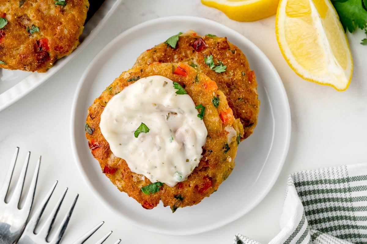 two salmon croquettes on a small white serving plate