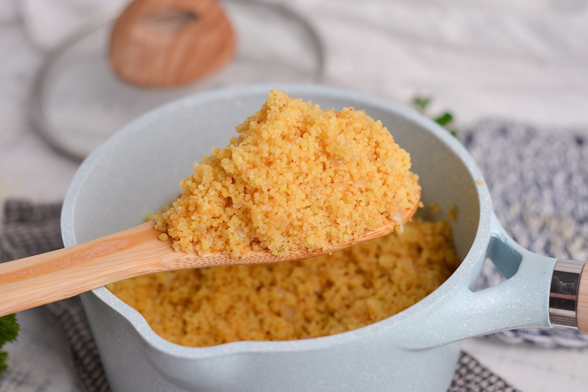 wooden spoon holding toasted couscous