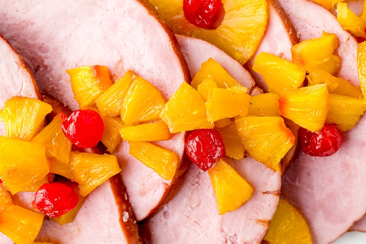 chopped up pineapples and cherries on ham slices