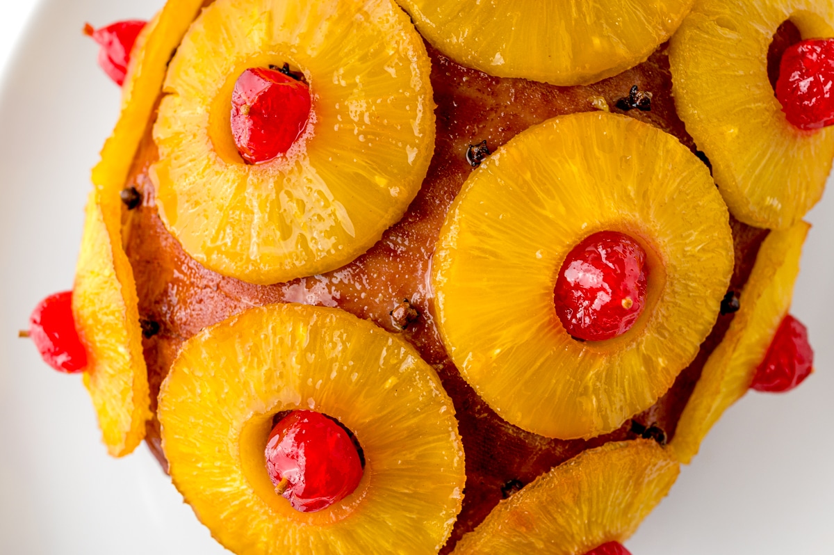 close up of glazed ham with pineapples and cherries