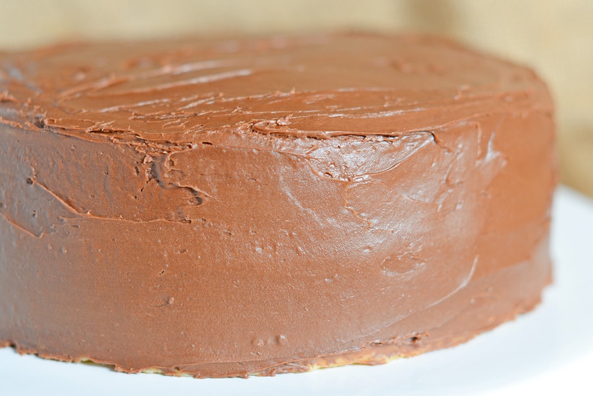 close up of chocolate frosting on a yellow cake