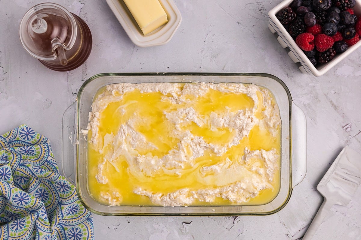 pouring melted butter over biscuit dough