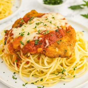 breaded chicken on plate of pasta