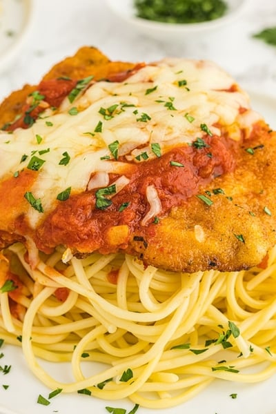 breaded chicken on plate of pasta