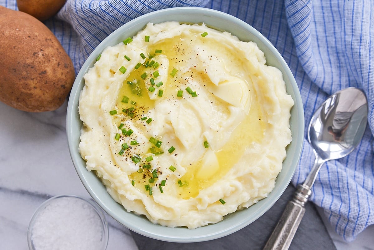 overhead bowl of mashed potatoes with butter and chives