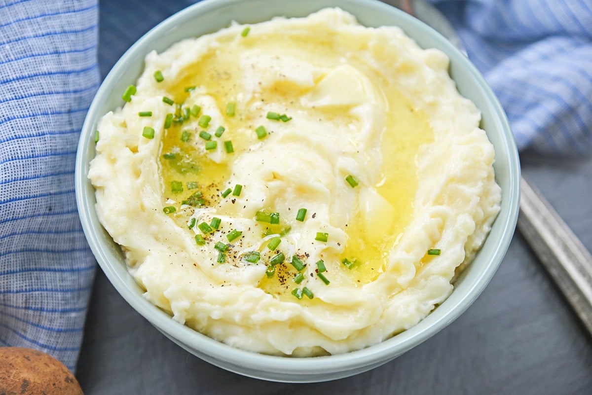 angle of mashed potatoes in a bowl with melted butter