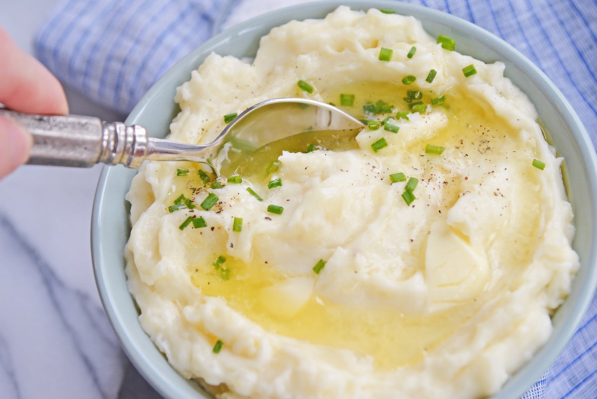 spoon digging into a bowl of mashed potatoes
