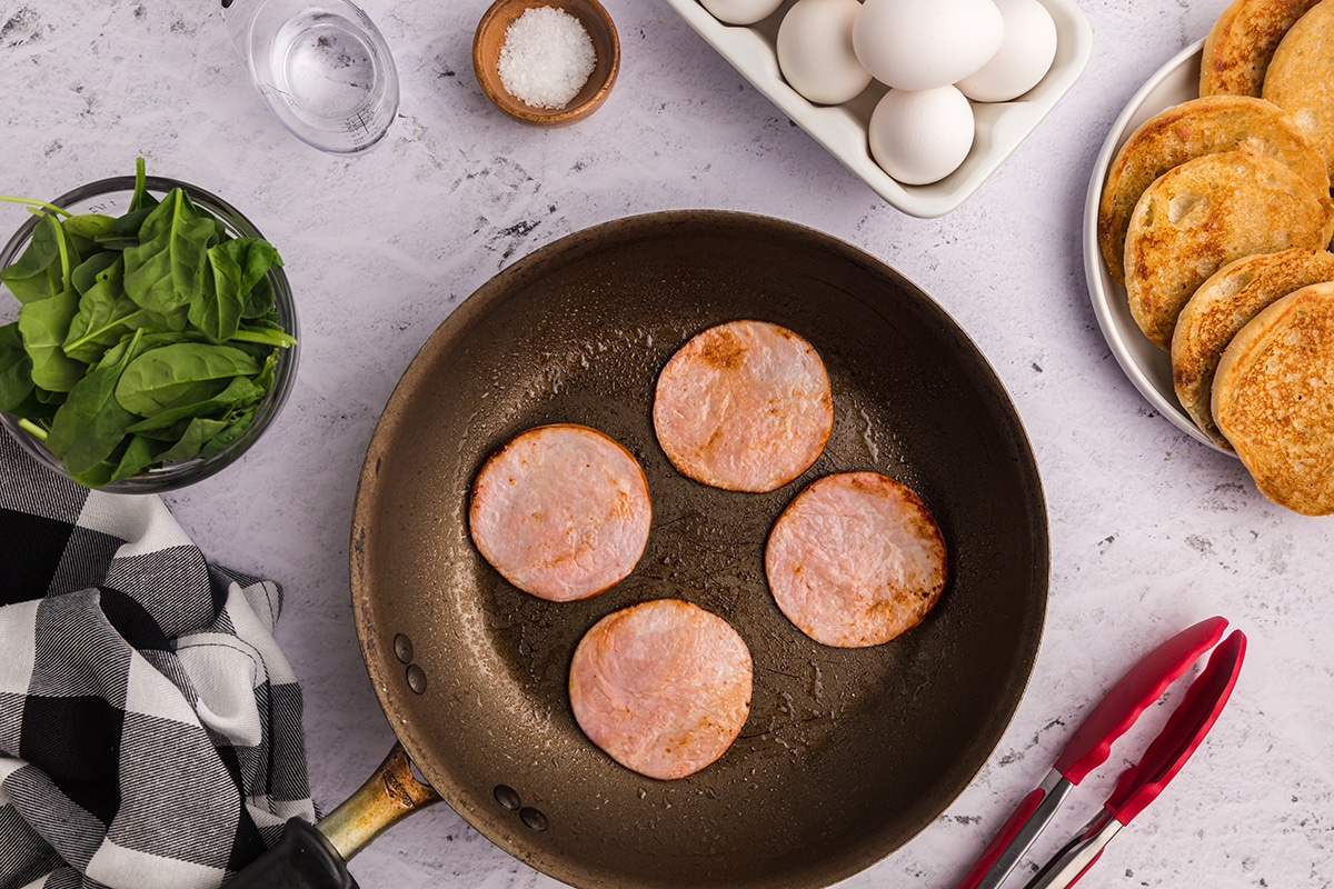 canadian bacon cooking in pan