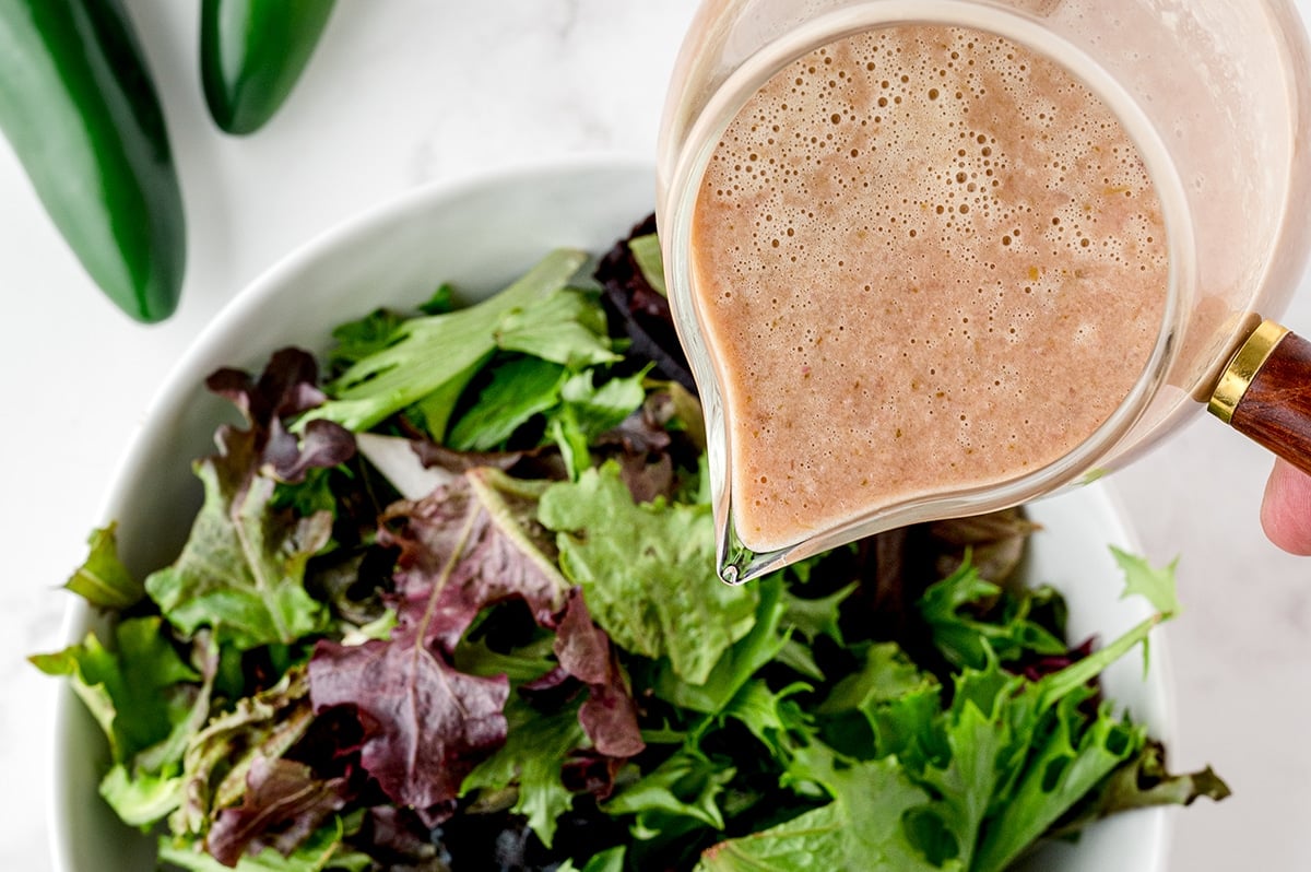 dressing poured onto a salad