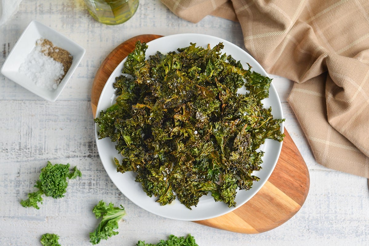 overhead of kale chips in a white plate