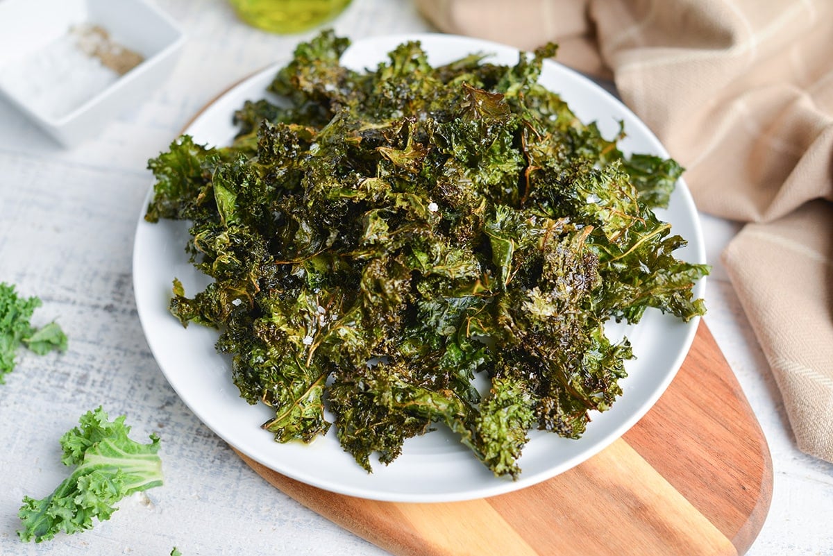 angle of kale chips on a white serving plate
