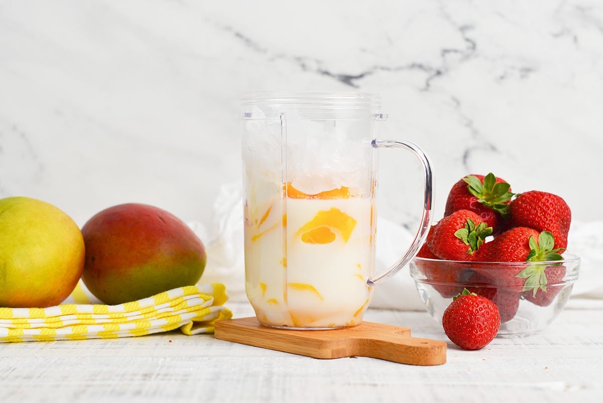 making a mango smoothie in a single blender