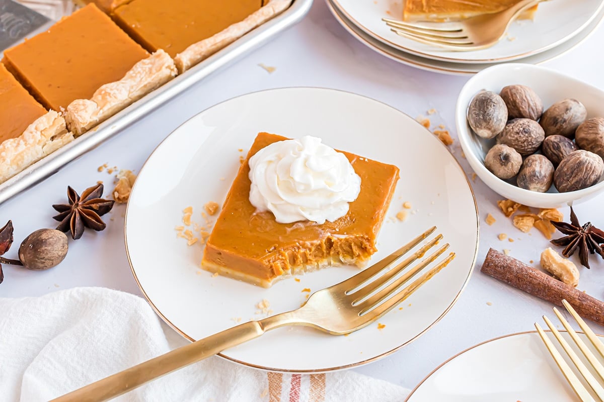 slice of pumpkin slab pie in a white plate with gold rim