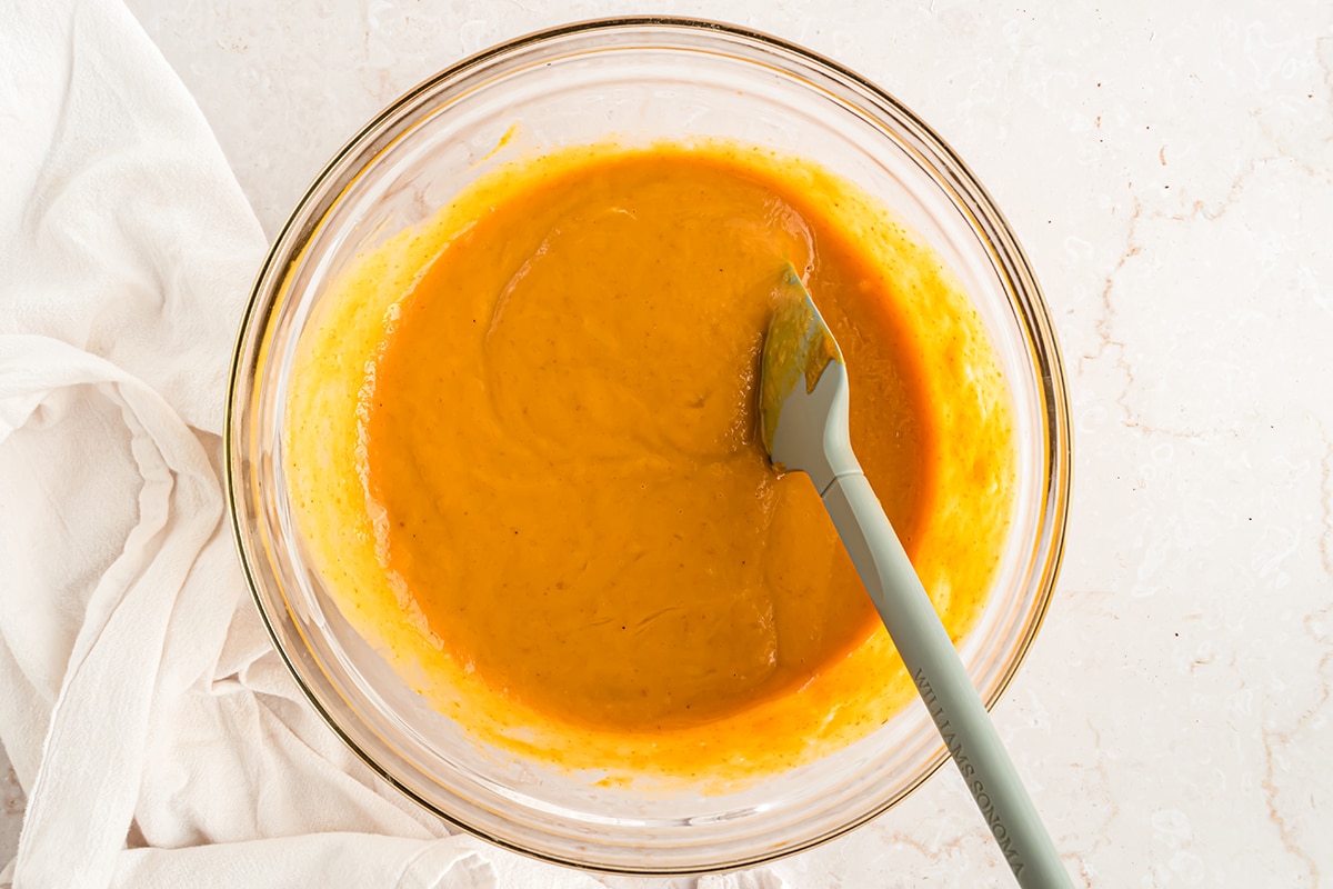 mixing pumpkin pie filling in a glass bowl