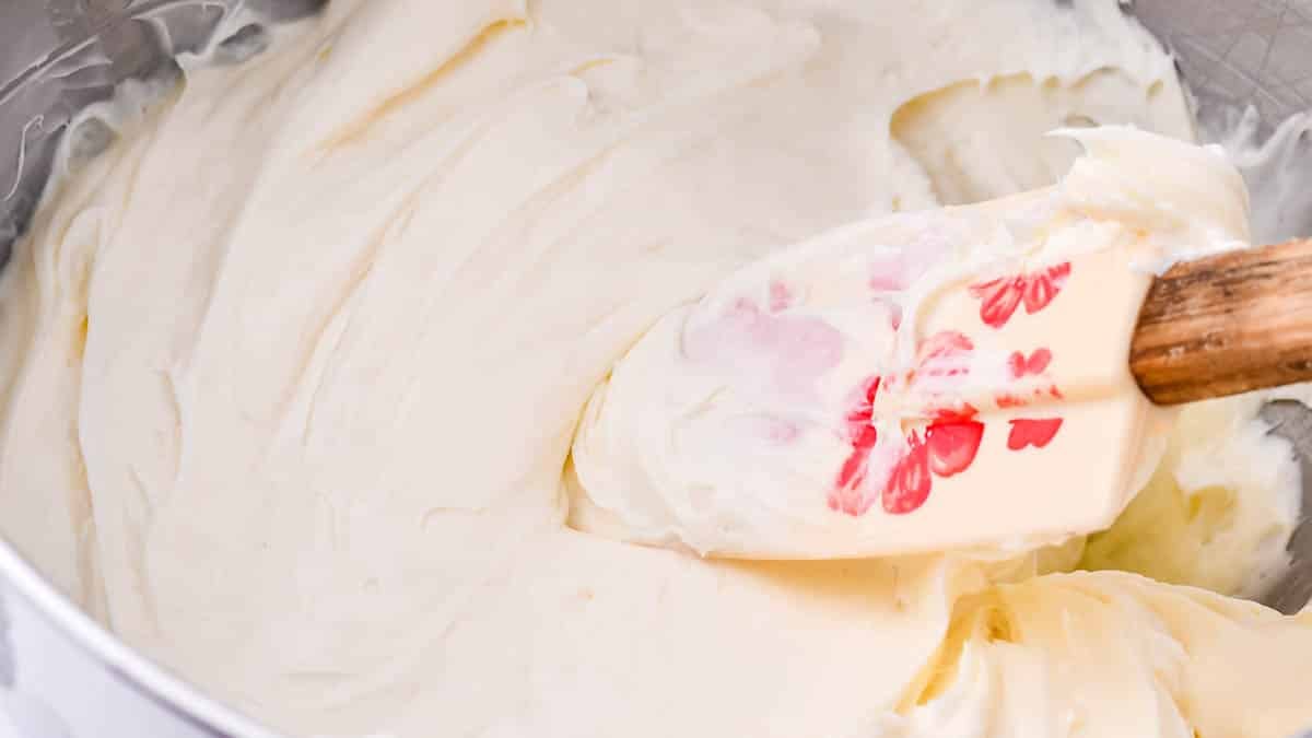 spatula stirring bowl of cream cheese frosting