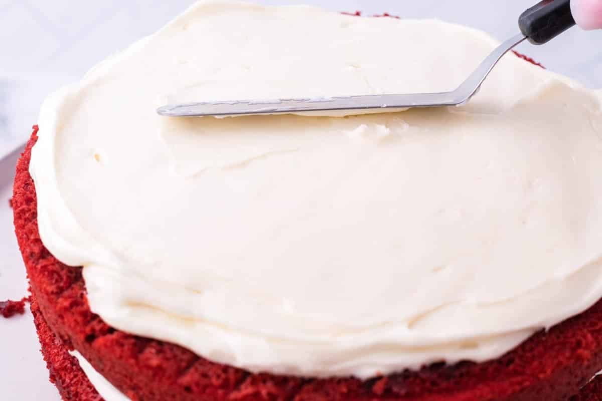 spatula spreading icing on cake layers