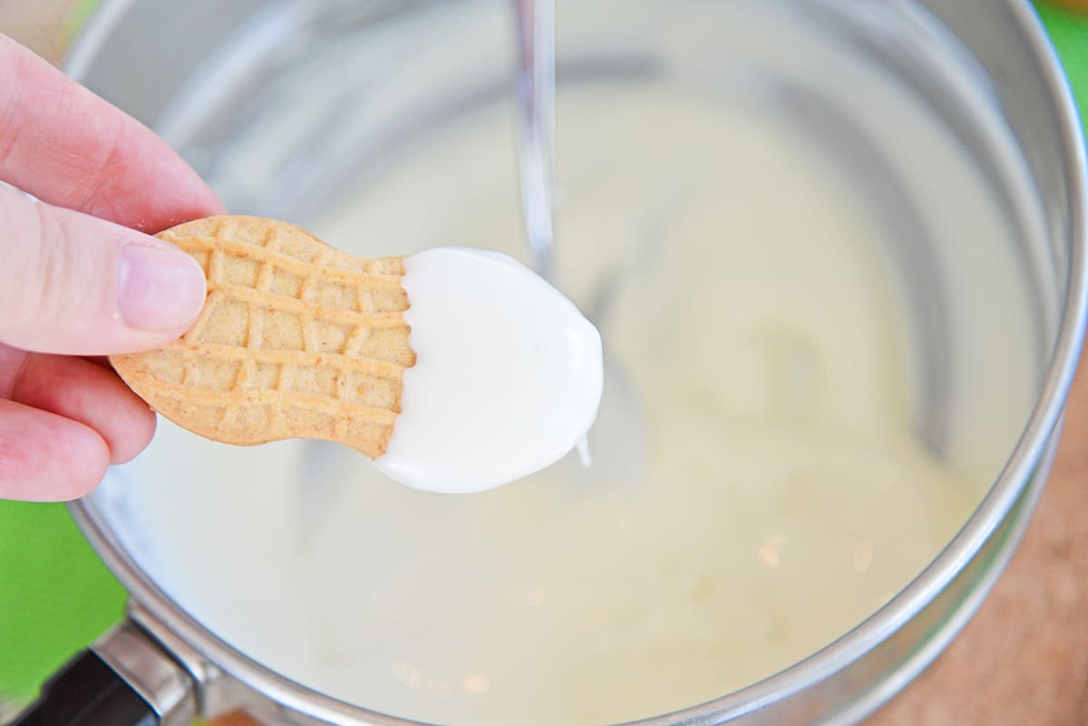 dipping a cookie in white chocolate