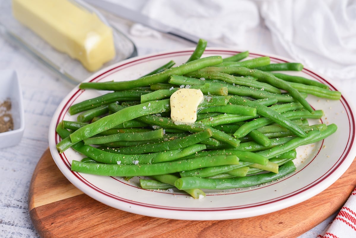 plated green beans with a pat of butter, salt and pepper