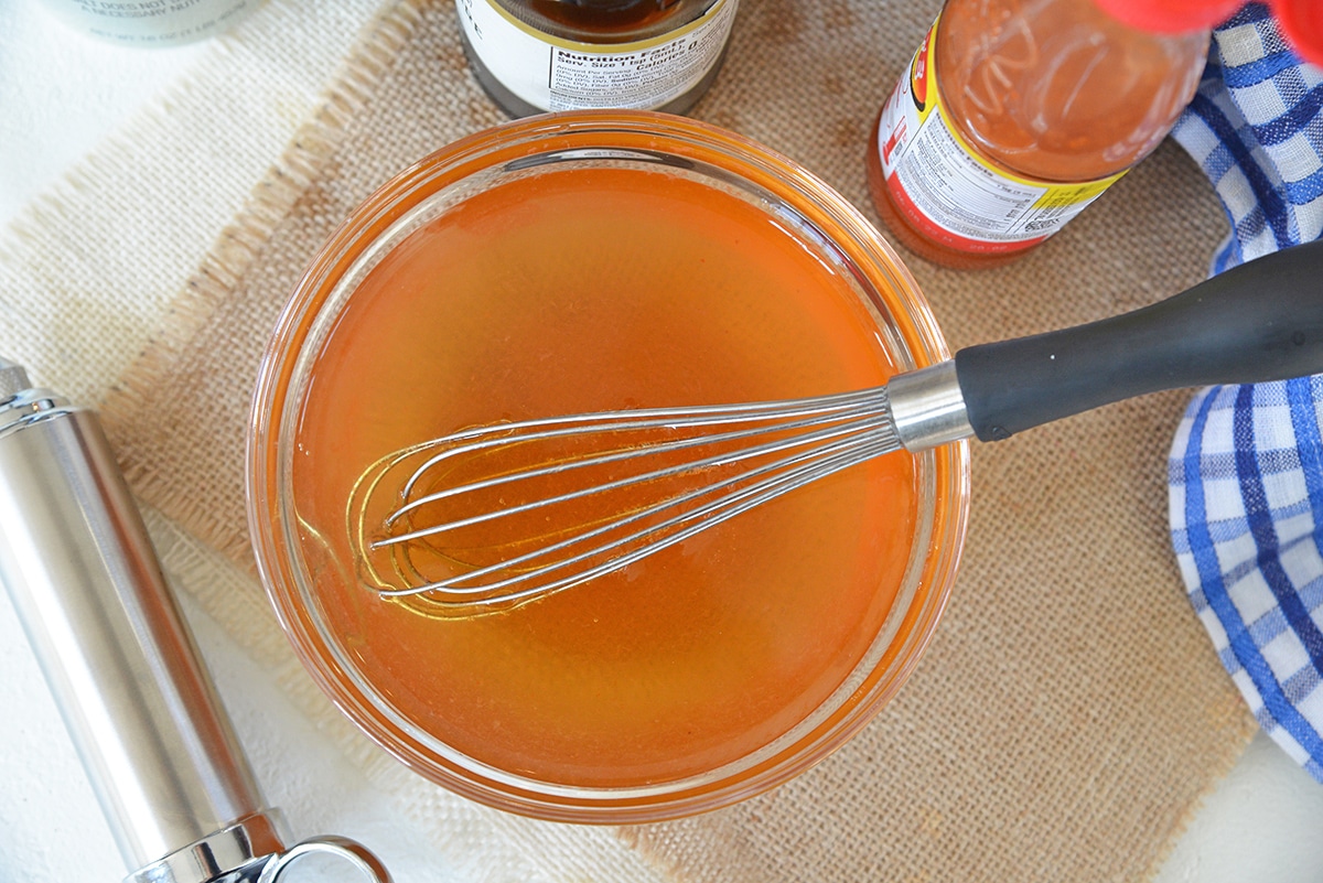 whisking together an injectable marinade in a small bowl