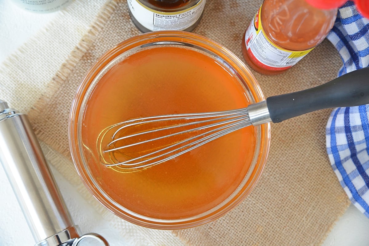 whisking together an injectable marinade in a small bowl