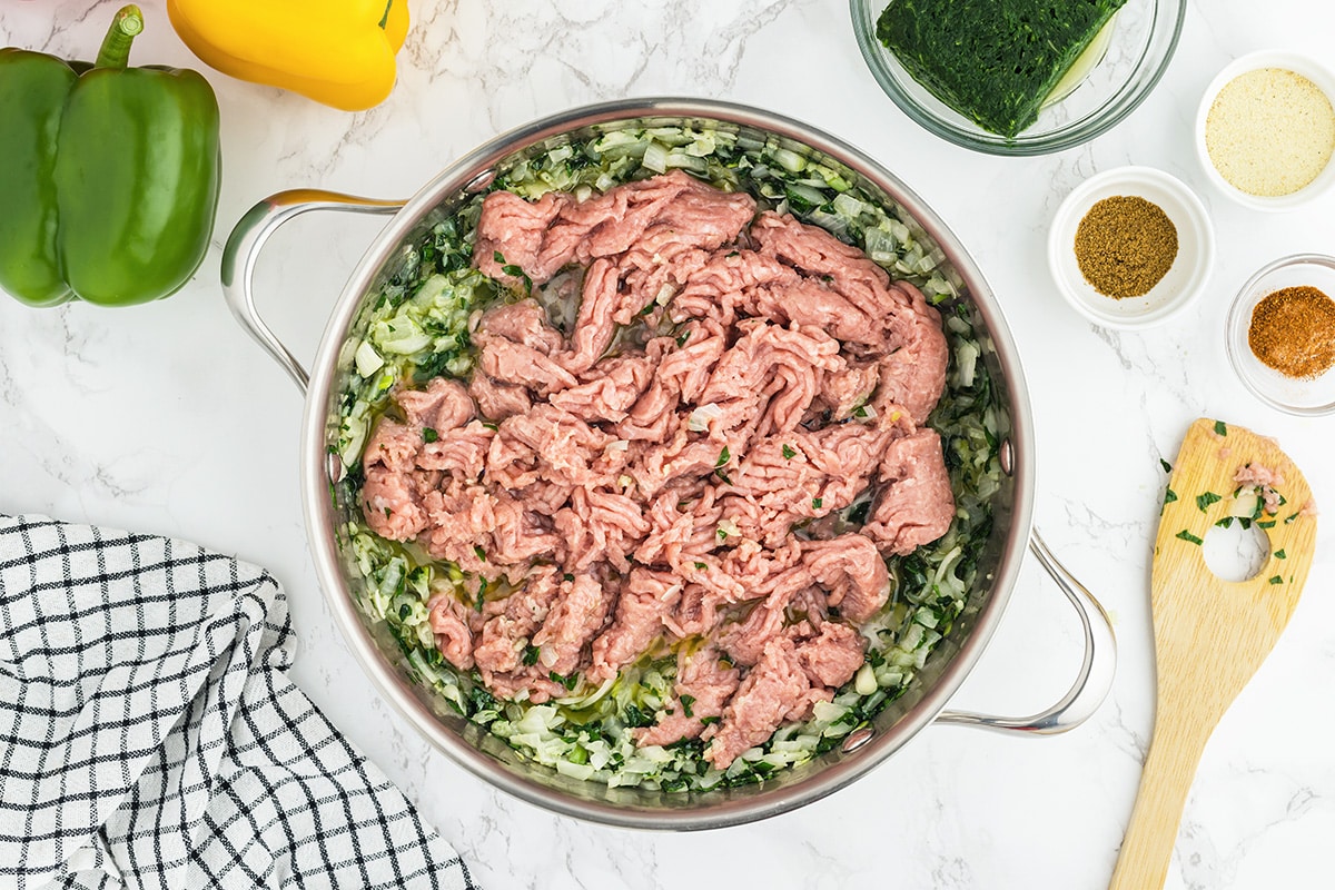 ground turkey in a frying pan with onion, garlic and parsley