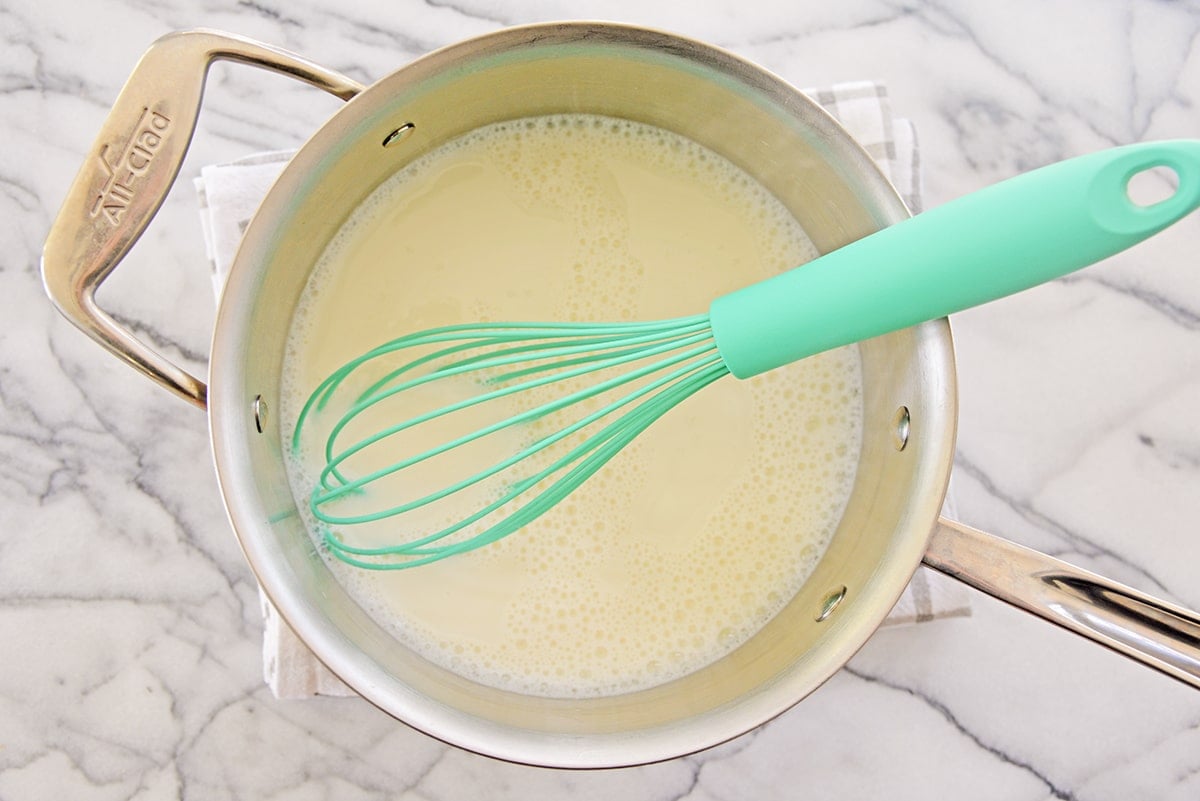 whisking custard mixture in a saucepan