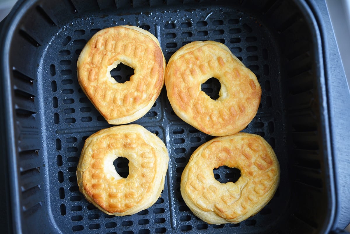 browned donuts in an air fryer basket