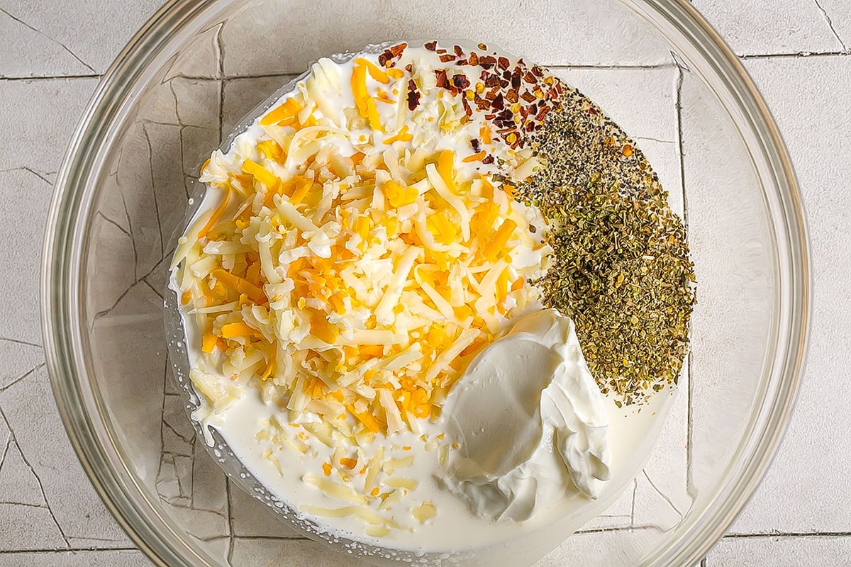 cheese, spices and cream in a glass mixing bowl