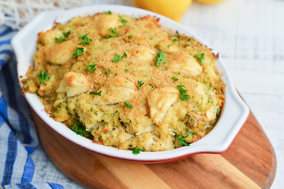 close up casserole dish of crab imperial on a wood board