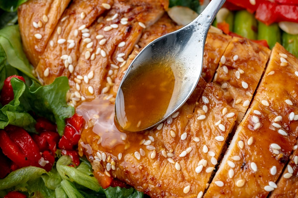 spoon pouring dressing on chicken