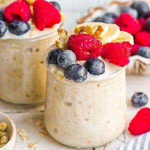 two jars of overnight oats topped with berries