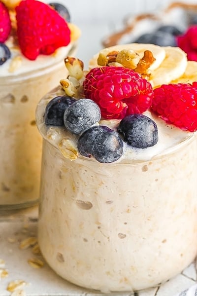 two jars of overnight oats topped with berries