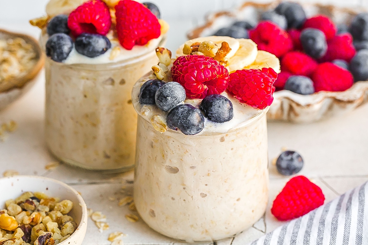 two jars of overnight oats topped with berries