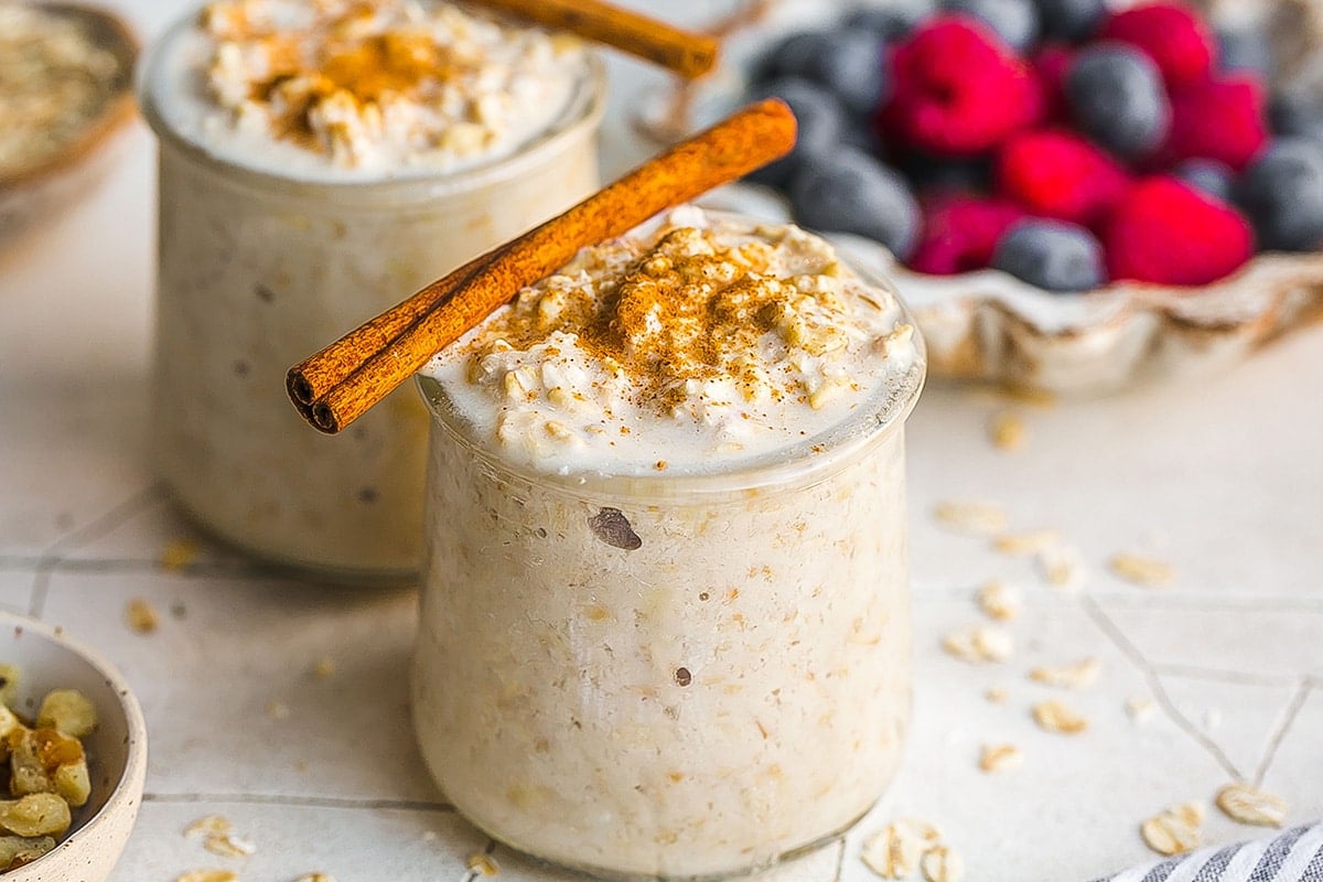 two jars of overnight oats topped with cinnamon
