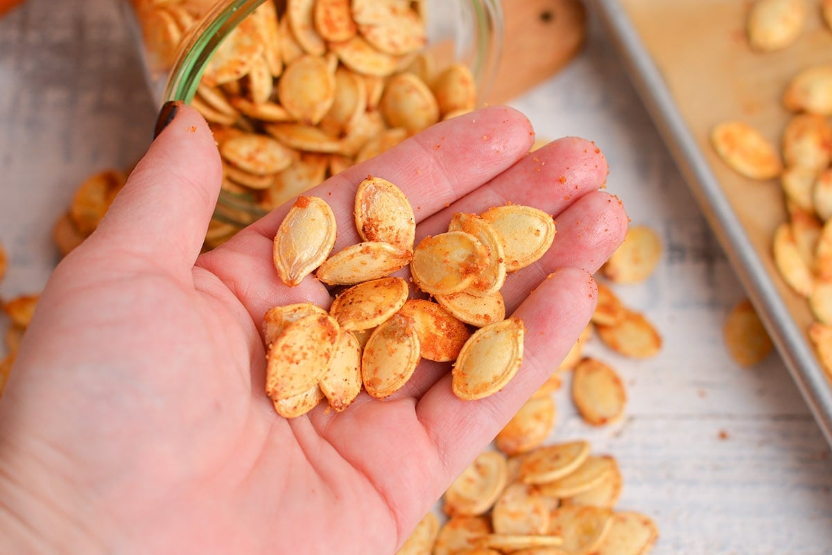 hand holding spiced pumpkin seeds