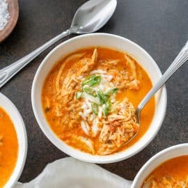 spoon in bowl of roasted red pepper soup