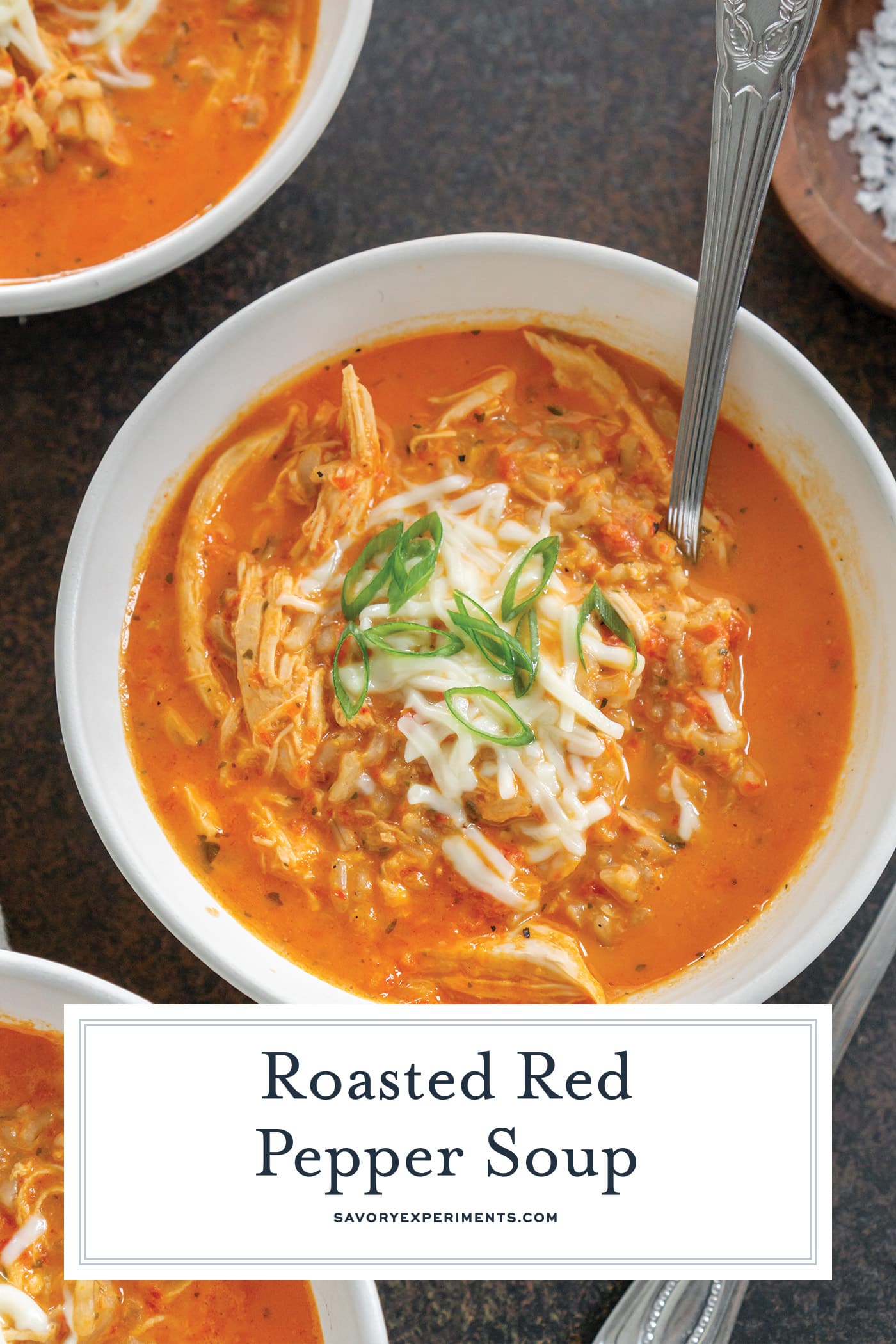 spoon in bowl of red pepper soup with text overlay for pinterest