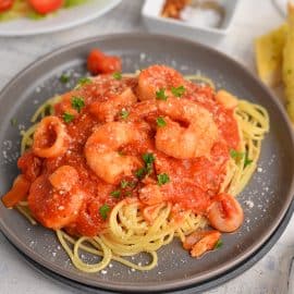 angle view of seafood fra diavolo recipe on a black serving plate