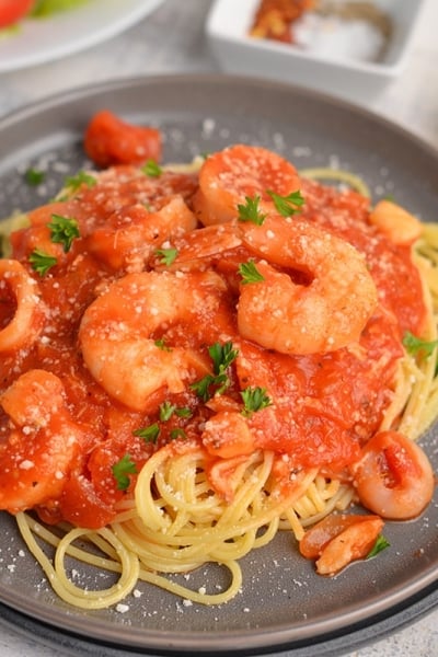 angle view of seafood fra diavolo recipe on a black serving plate