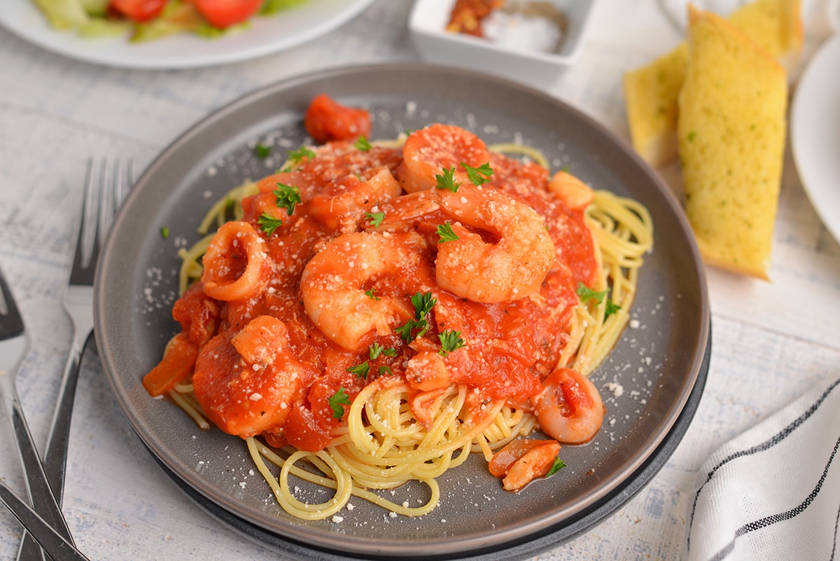 angle view of seafood fra diavolo recipe on a black serving plate