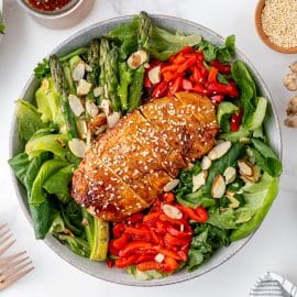 sticky chicken sliced on top of salad