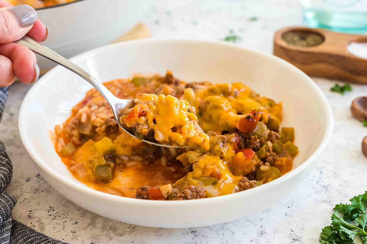 spoon digging into bowl of stuffed pepper casserole