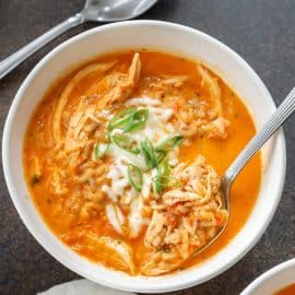 spoon in bowl of roasted red pepper soup