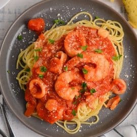 overhead of seafood fra diavolo with salad and breadsticks