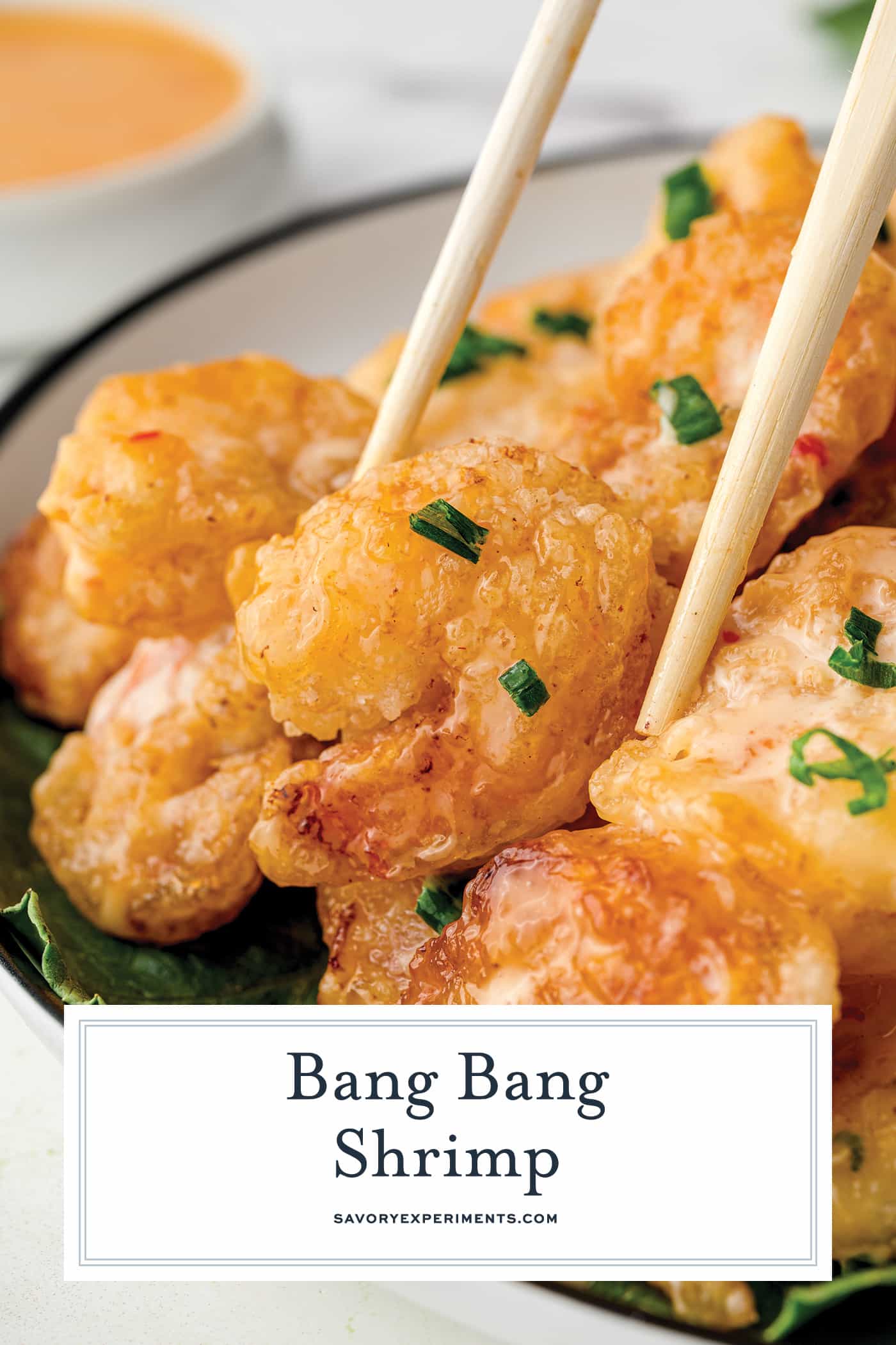 chopsticks grabbing bang bang shrimp with text overlay for pinterest