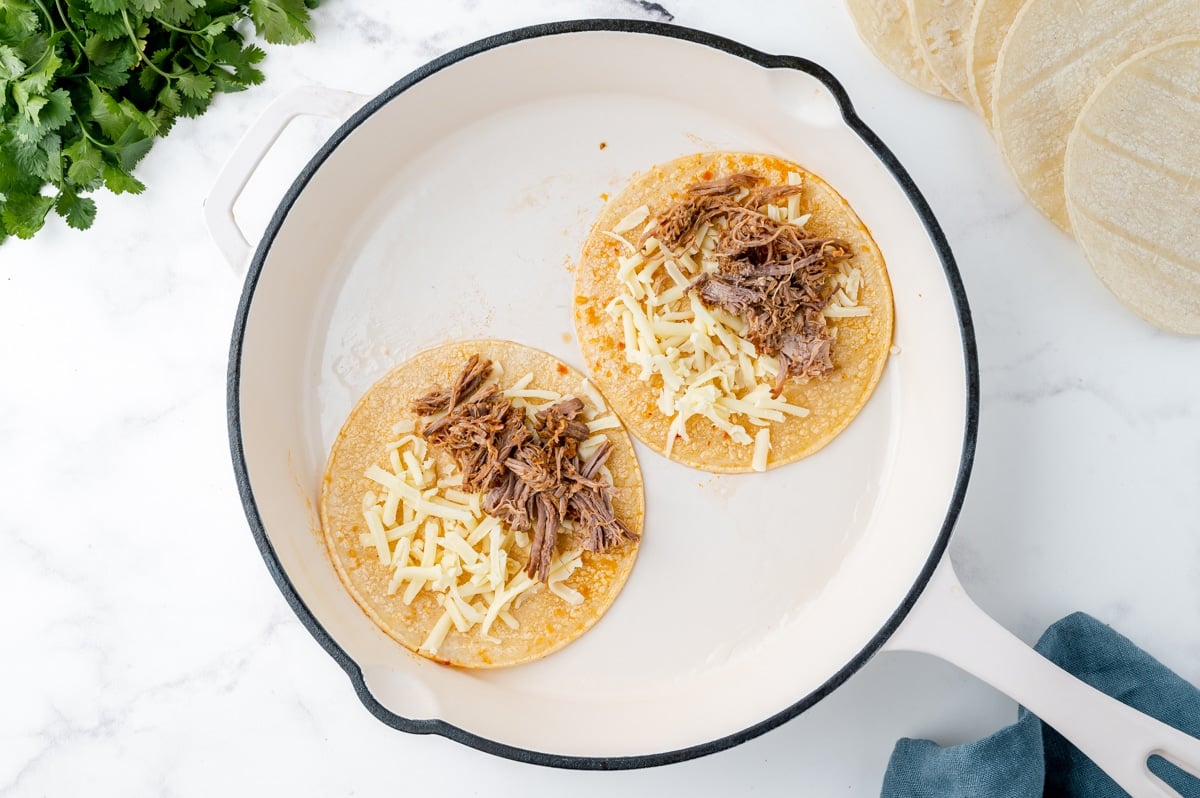 tortillas with pork and cheese in pan