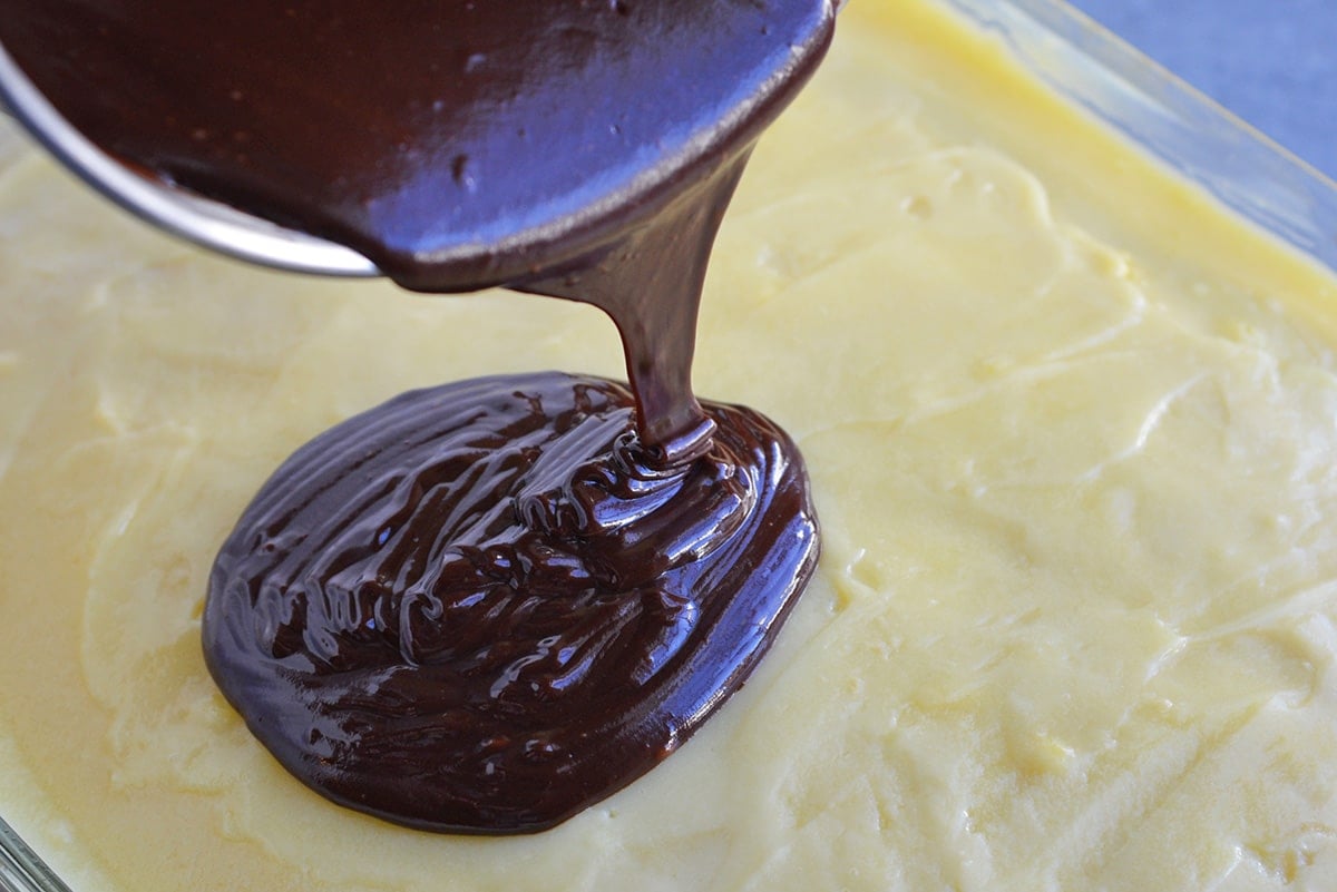 Chocolate ganache pouring onto a Boston Cream Pie