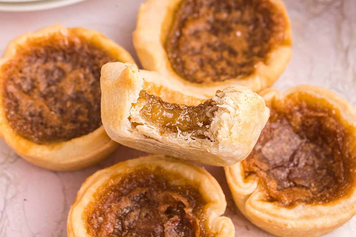 close up of bite taken out of a butter tart recipe