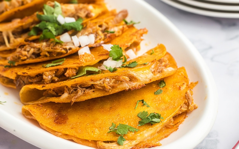 inside of chicken taco topped with cilantro and chopped onions